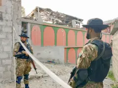 يقف جنودٌ من باكستان في حالة تأهبٍ أمام مسجدٍ بعد غاراتٍ هنديةٍ في مظفر آباد، عاصمة الشطر الباكستاني من كشمير
