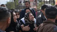 İranın paytaxtı Tehranda xilasedicilərdən qohumunun meyitini alarkən ona ağı deyən qadın. 27 mart 2026-cı il.