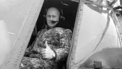 Чорнобіле фото військового льотчика, який виглядає з кабіни вертольота 