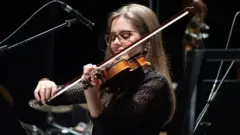 Otielen Santos tocando em orquestra