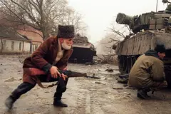 Пожилой чеченец с автоматом перебегает улицу под обстрелом