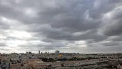 تظهر هذه الصورة من جبل الزيتون أسوار مدينة القدس القديمة ومسجد قبة الصخرة في مجمع الأقصى تحت سماء ملبدة بالغيوم في 28 ديسمبر/كانون الأول 2024.