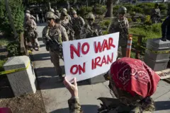 Protester hold sign in front of United States Marine Corps 