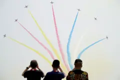FILE PHOTO: People watch Chinese People's Liberation Army (PLA) Air Force Red Falcon aerobatic team perform at the China International Aviation and Aerospace Exhibition, or Airshow China, in Zhuhai, Guangdong province, China September 28, 2021. REUTER