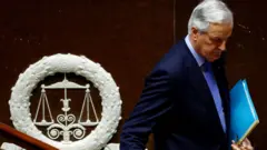 Michel Barnier leaves the stage after delivering a speech in parliament