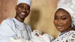 Lateef Adedimeji ati Mo Bimpe iyawo rẹ, gbe ọkan ninu awọn ibẹta wọn dani. Wọn wọṣo funfun.