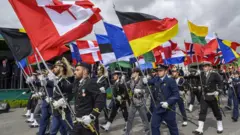 नेटोका सदस्यराष्ट्रहरूको झण्डा बोकेर परेड गर्दै पोर्चुगलका सैनिकहरू