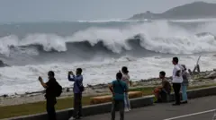花莲民众在岸边观看台风巴威带来的巨浪
