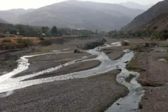 Pessoas fazem piquenique em um rio quase seco que, antes, era cheio de água na região de Fasham, ao norte de Teerã, no dia 25 de agosto de 2025