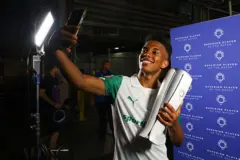 Jogador segura o troféu e faz uma selfie