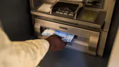Foto of man wey dey use ATM for Nigeria 
