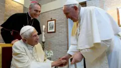 Iyi niyo sanamu ifatwa ko ari iya vuba ya Benoit, hano akaba yariko aramukanya na Papa Francis mu mu kigo c’abihebeye Imana muri Myandagaro 
