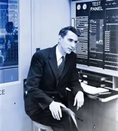 Shannon sentado em frente a um painel de teste