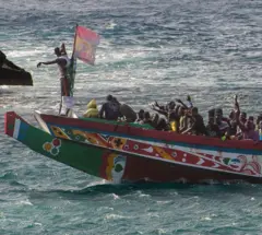 Un groupe de migrants célèbre son sauvetage en mer lors de la traversée entre l'Afrique et l'Europe, quelques minutes avant d'entrer dans le port de La Restinga, aux îles Canaries. 