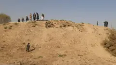 چند مرد بر فراز تپه دیده می‌شوند و چند کودک هم در حال بالا رفتن از آن هستند