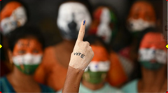 An Indian student's finger pointed in the air, with the word "vote" on the hand, to promote voting in the election