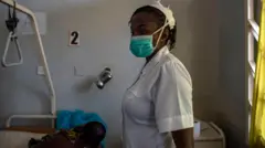 Aworan nọọsi obinrin kan ni yara itọju pẹlu ẹni to n gba itọju