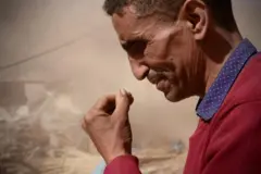 Un homme pleure devant des décombres