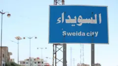 Дорожный знак на въезде в город Сувейда