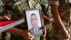 Muškarac drži fotografiju poginulog vojnika