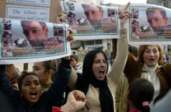 تظاهرة لأطفال فلسطينيين مع نشطاء في ذكرى مقتل توم هرندل في مخيم رفح للاجئين، جنوب قطاع غزة، في 16 يناير/كانون الثاني 2004