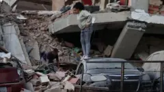 Moradores entre os escombros em Catia la Mar, no estado de La Guaira, o mais afetado.