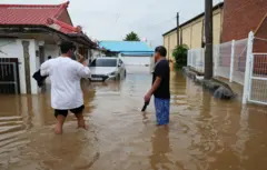 17일 오전 침수 피해를 겪은 충남 예산군 주민들이 잠긴 도로 위를 걸어다니고 있다