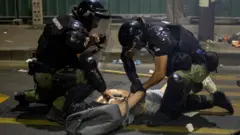 Полицијаци хапсе демонстранта током антивладиног протеста у јуну 2025.