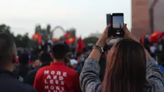 Protestuющaя fotografiruet demonstrantov