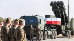 Польские военные стоят возле пусковой установки противовоздушной обороны Patriot, установленной на военной базе.