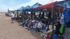 Roupas de segunda mão à venda em barracas, em um mercado a céu aberto na cidade chilena de Alto Hospicio