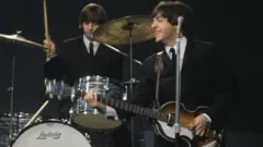 Ringo Starr and Paul McCartney (playing a Hofner 500/1 violin bass guitar) on stage during recording of the American Broadcasting Company (ABC) music television show 'Shindig!' at Granville Studios in Fulham, London on 3rd October 1964