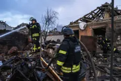 Bombeiros apagam incêndio em meio a escombros de uma casa após o bombardeio russo na cidade de Sloviansk, Ucrânia, em 21 de fevereiro de 2025