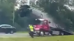 Car going up a ramp of a tow truck on a highway in Georgia