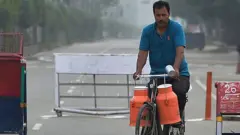 పాల క్యాన్లతో వెళ్తున్న వ్యక్తి