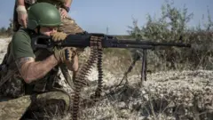 Un Ukrainien tire avec une mitrailleuse.