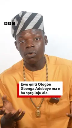 Zacheus Olaoluwa wọ asọ sokoto ati ẹwu alawọ ofeefee, o si de fila asọ oke alawọn eeru ati dudu, o tẹ ọwọ siwaju, o si fi ẹgba goolu si ọrun