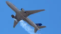 Flames are seen coming from the engine of flight UA328