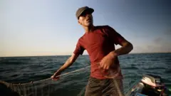 ผู้ชายบนเรือในทะเล