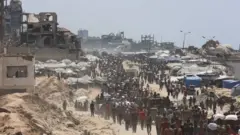 Pessoas caminhando em meio a edifícios destruídos