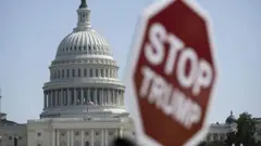 Плакат с надписью "Остановите Трампа" на фоне здания Капитолия