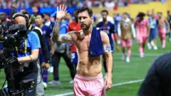 Lionel Messi em campo acenando