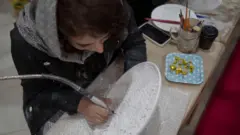 زنی مشغول کار روی صنایع دستی در شهر تبریز در شمال غرب ایران