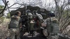 Ukrainian artillerymen check the weapons and special equipment to make them ready before they go to their duties at the frontline in Kherson, in July 2022
