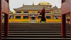 Um monge passa pelos portões de um mosteiro em Aba