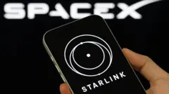 смартфон із заставкою Starlink на тлі лого SpaceX