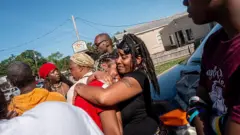 Una mujer recibe consuelo mientras llora la muerte de sus sobrinas y sobrinos el 19 de abril de 2026 en Shreveport, Luisiana. 