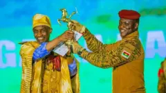 Dani Kouyaté reçoit l'Etalon d'or de Yennega des mains du capitaine Ibrahim Traoré.