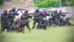 Aworan awọn ṣọja kan ti wọn duro gbagbagba pẹlu ibọn wọn.