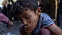 Menino se alimentando em Gaza